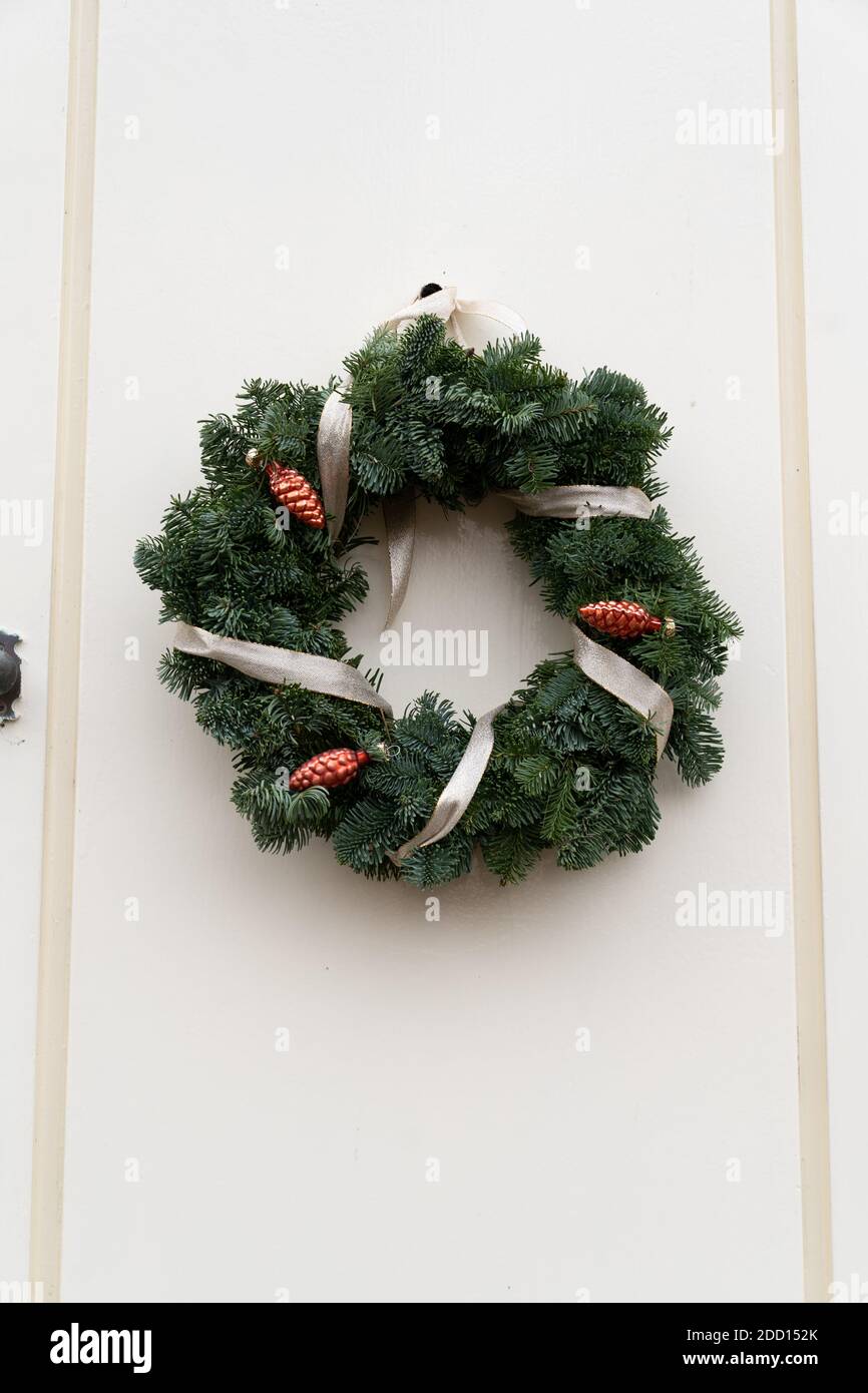 Beautiful door is decorated for Christmas with an evergreen wreath ...