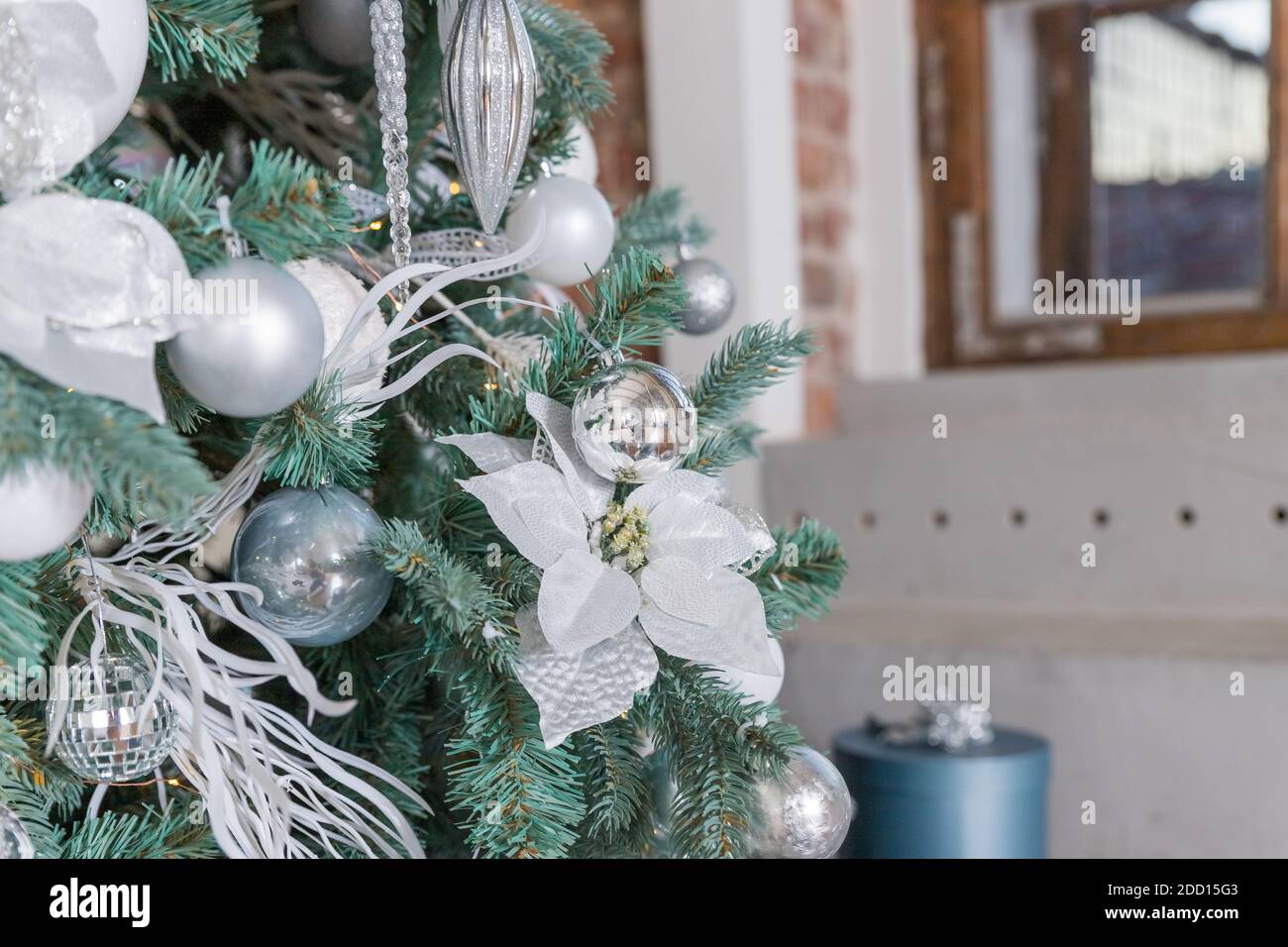 Christmas tree branch decorated with silver balls and white decor ...