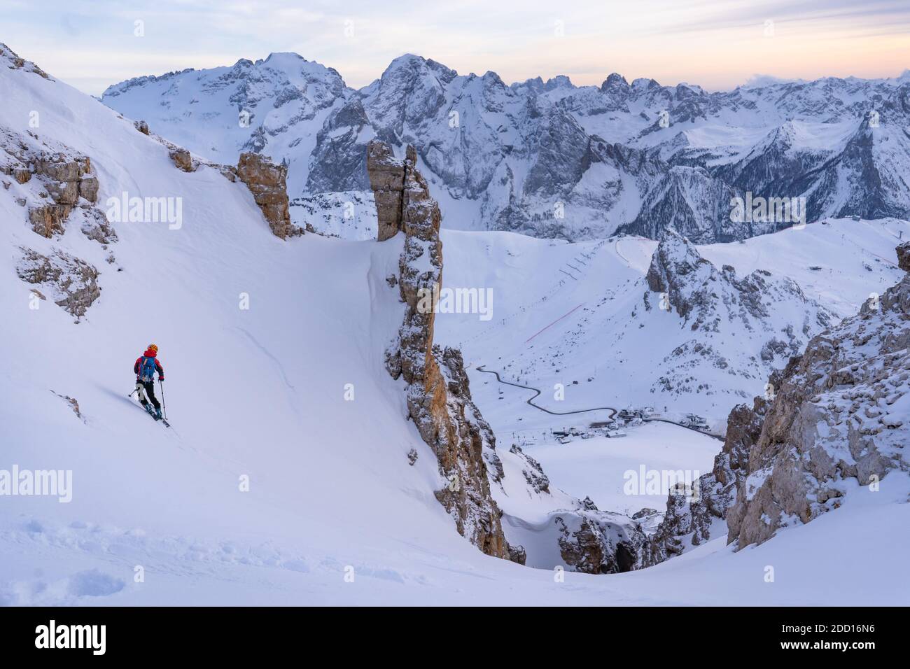 Skier dropping down in Joel couloir with the sunset and Marmolada range in front. Sass Pordoi, Dolomitas Stock Photo