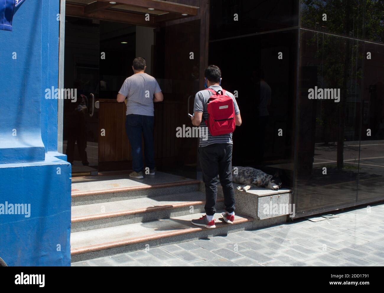 CORDOBA, ARGENTINA- 5 OF NOVEMBER 2020- Two men waiting in line outside to enter in a building Stock Photo