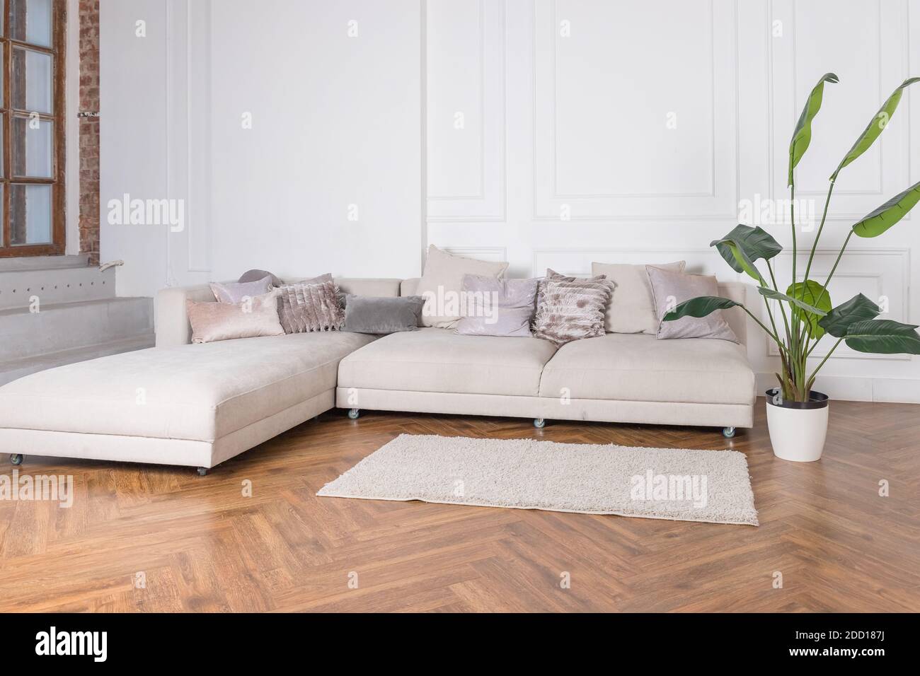 Modern luxury stylish apartment interior in pastel colors. a very bright room, daylight. white walls, wooden parquet floors, carpet.Bright living room Stock Photo