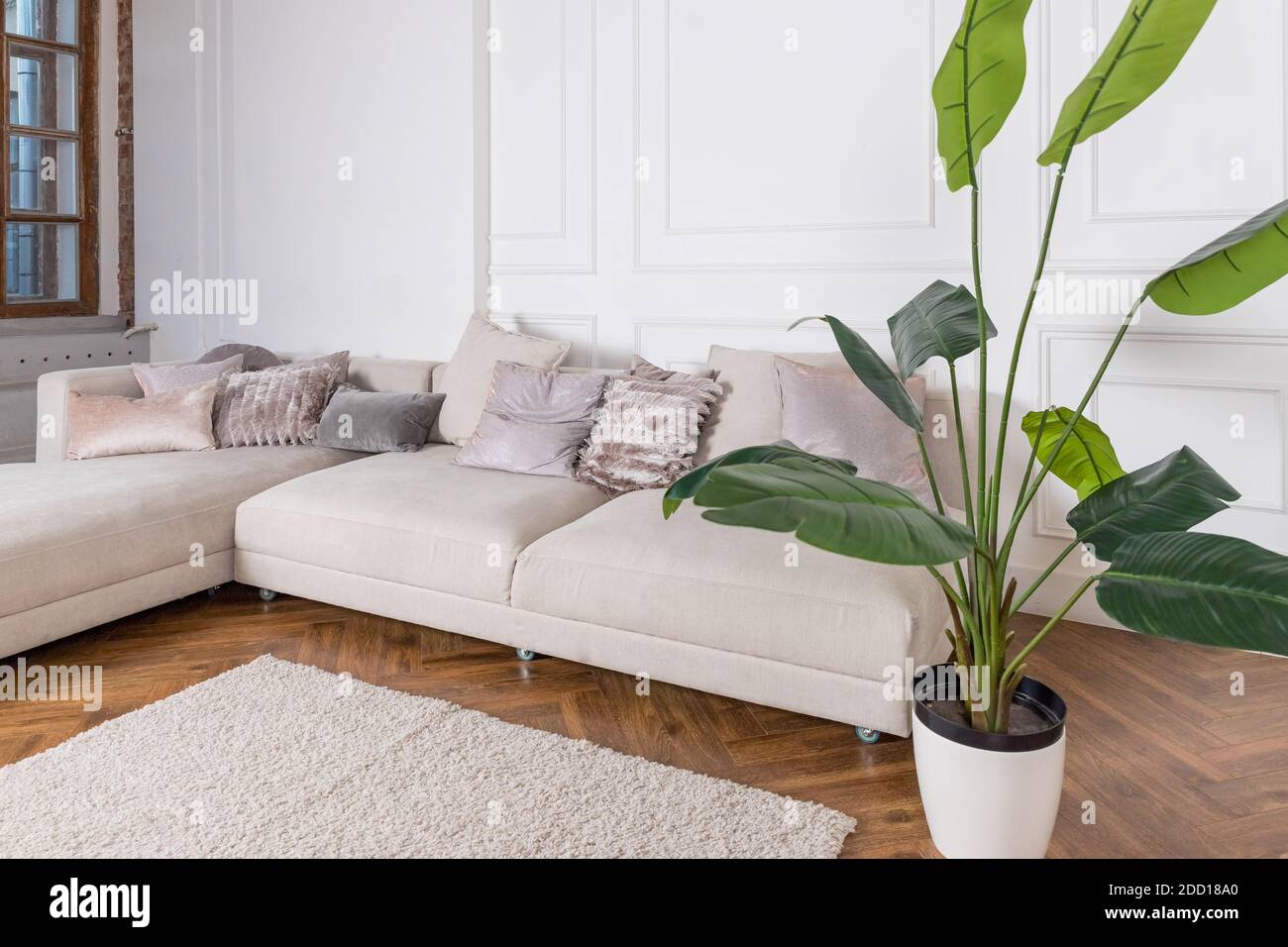 Modern luxury stylish apartment interior in pastel colors. a very bright room, daylight. white walls, wooden parquet floors, carpet.Bright living room Stock Photo