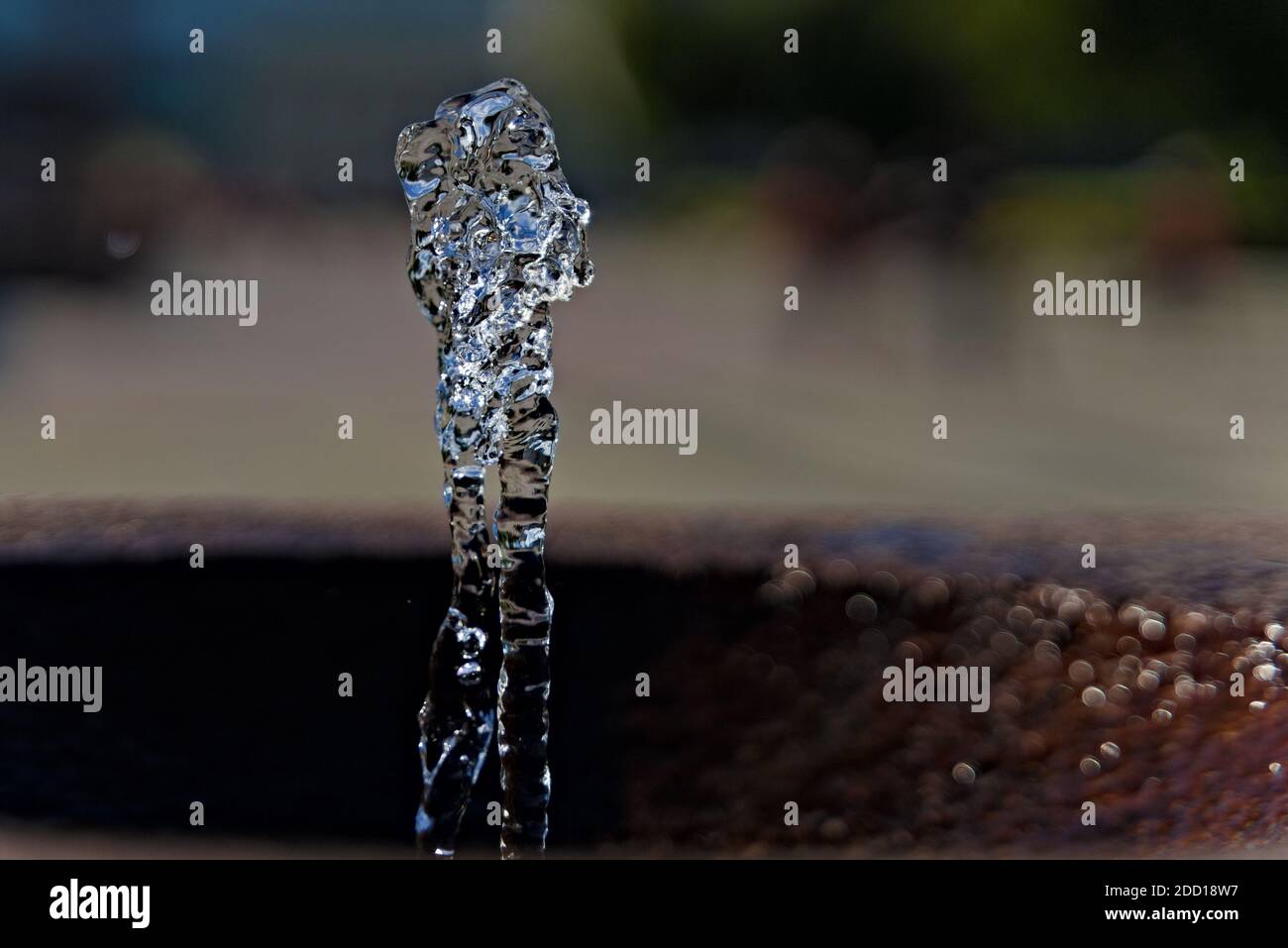 Water springing from a public faucet, suspended in the air. shallow ...