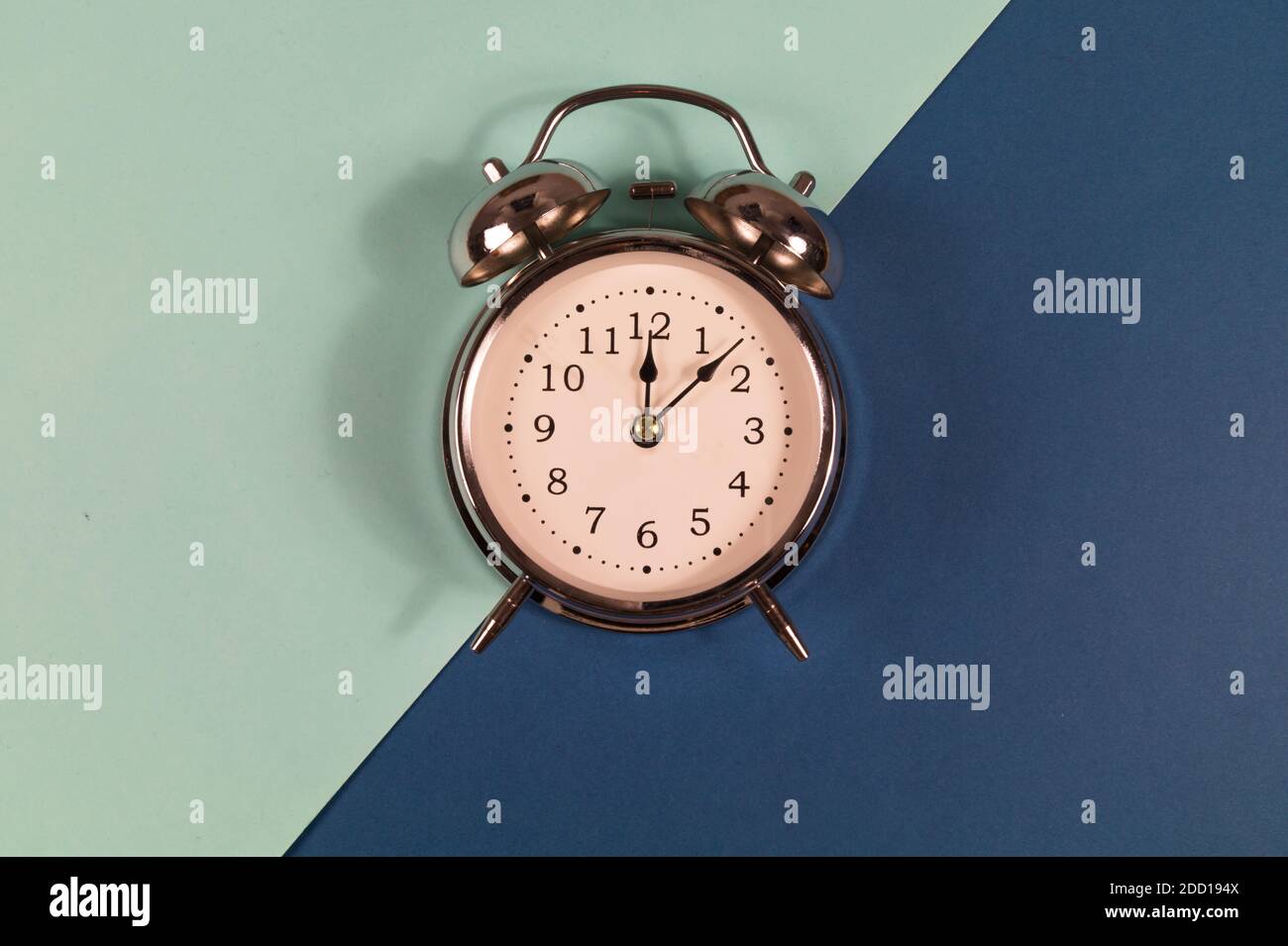 Old vintage alarm clock on two color background. Stock Photo