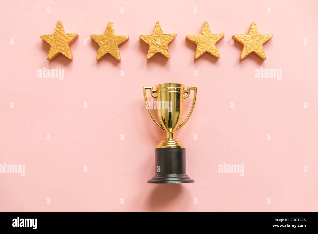 Simply flat lay design winner or champion gold trophy cup and 5 stars rating  isolated on pink pastel background. Victory first place of competition. W  Stock Photo - Alamy