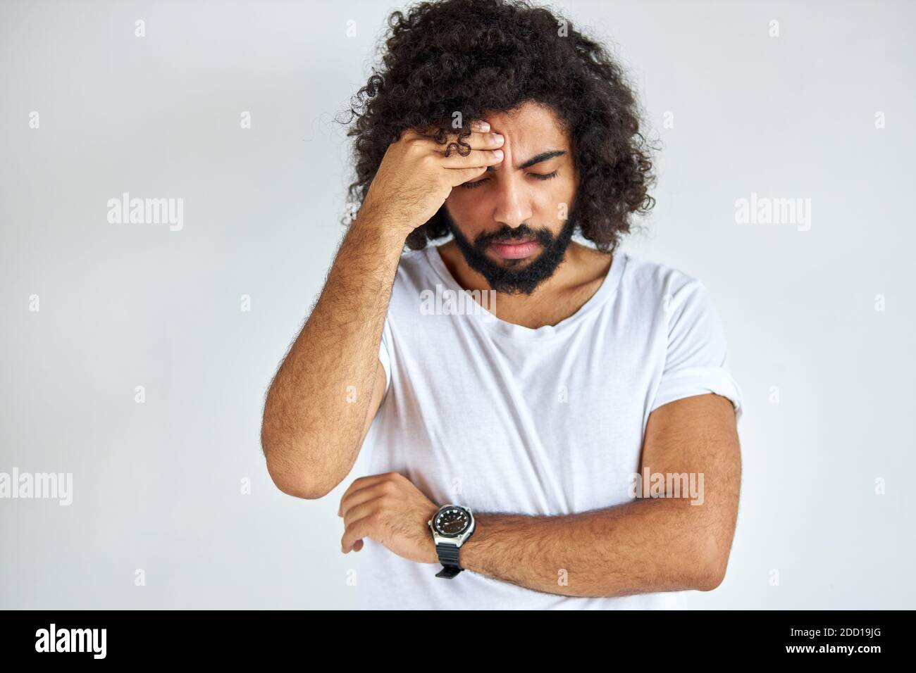 young arabian indian guy with long hair has head ache, he is suffering from migraine, he has a migraine attack. isolated white background Stock Photo