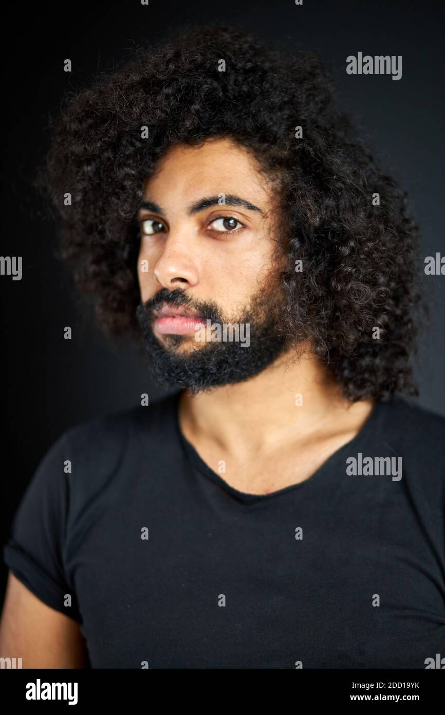 portrait of pleased arab man isolated in studio, handsome guy in casual  wear posing at camera, has black long curly hair, calm male of indian or  arabian appearance Stock Photo - Alamy