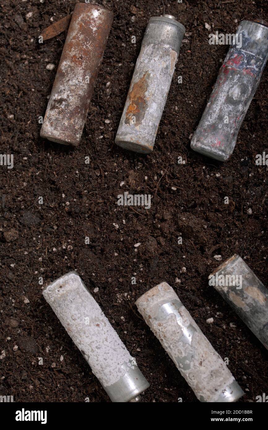 A corroded battery is lying on the ground. Environmental protection and