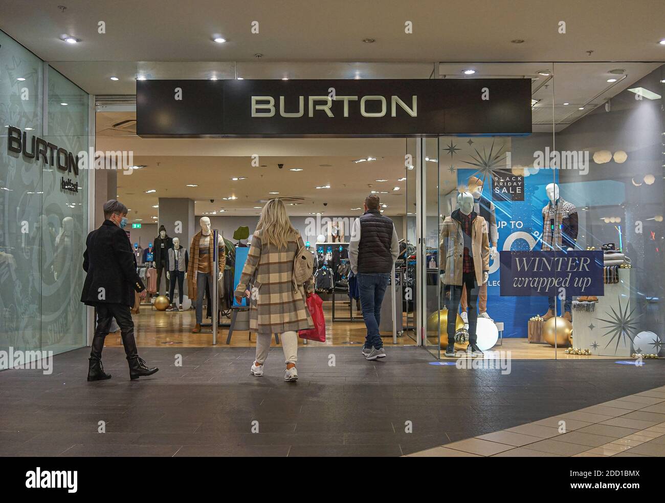 Customers wearing face masks are seen entering Burton Store. Stock Photo