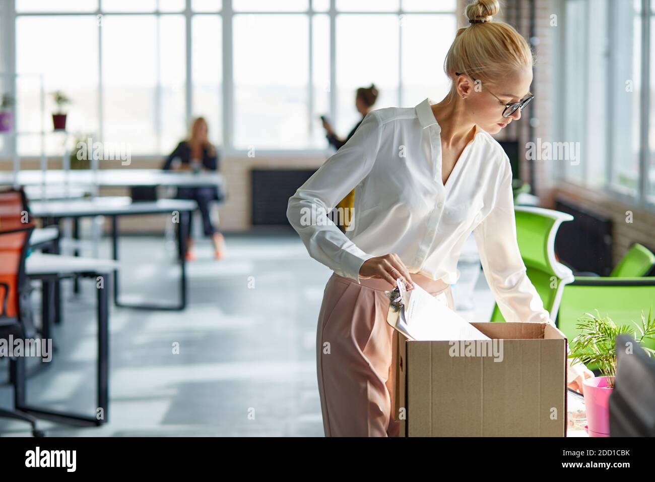 caucasian female employee intern holding cardboard box with belongings start or finish job in company, blonde busnesswoman newcomer worker get hired fired on first last day at work concept Stock Photo