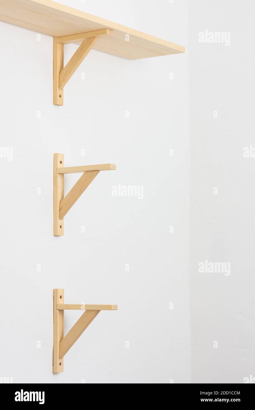The process of attaching a wooden shelf to the wall, shelf corners