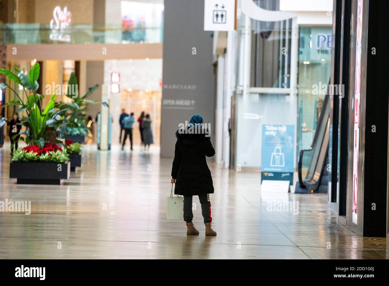 Person speaks on the phone at Yorkdale Shopping Centre during a renewed coronavirus lockdown due to a spike in cases in Toronto, Ontario, Canada November 23, 2020. REUTERS/Carlos Osorio Stock Photo