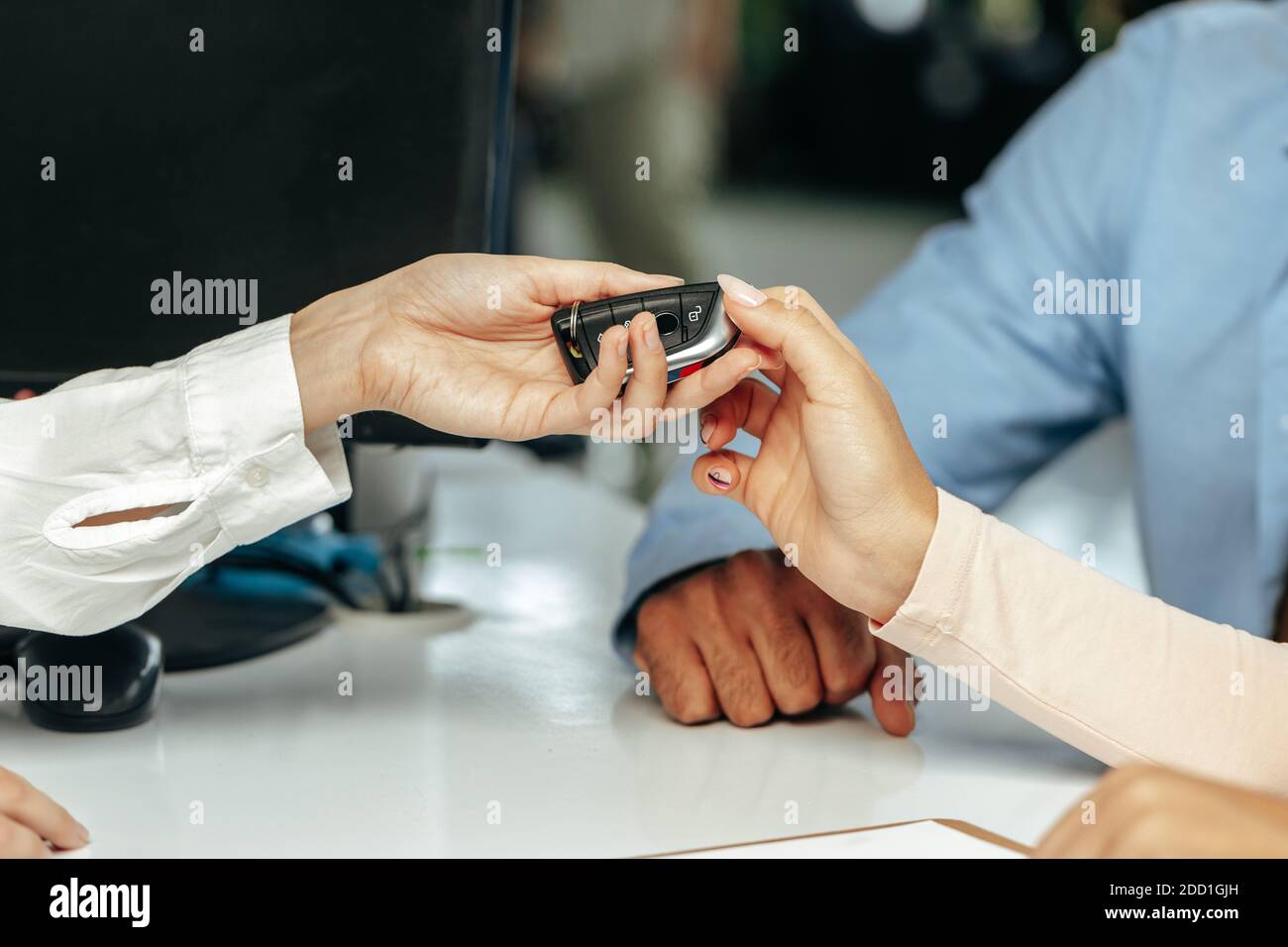 Car salesperson giving keys to a client close up Stock Photo - Alamy