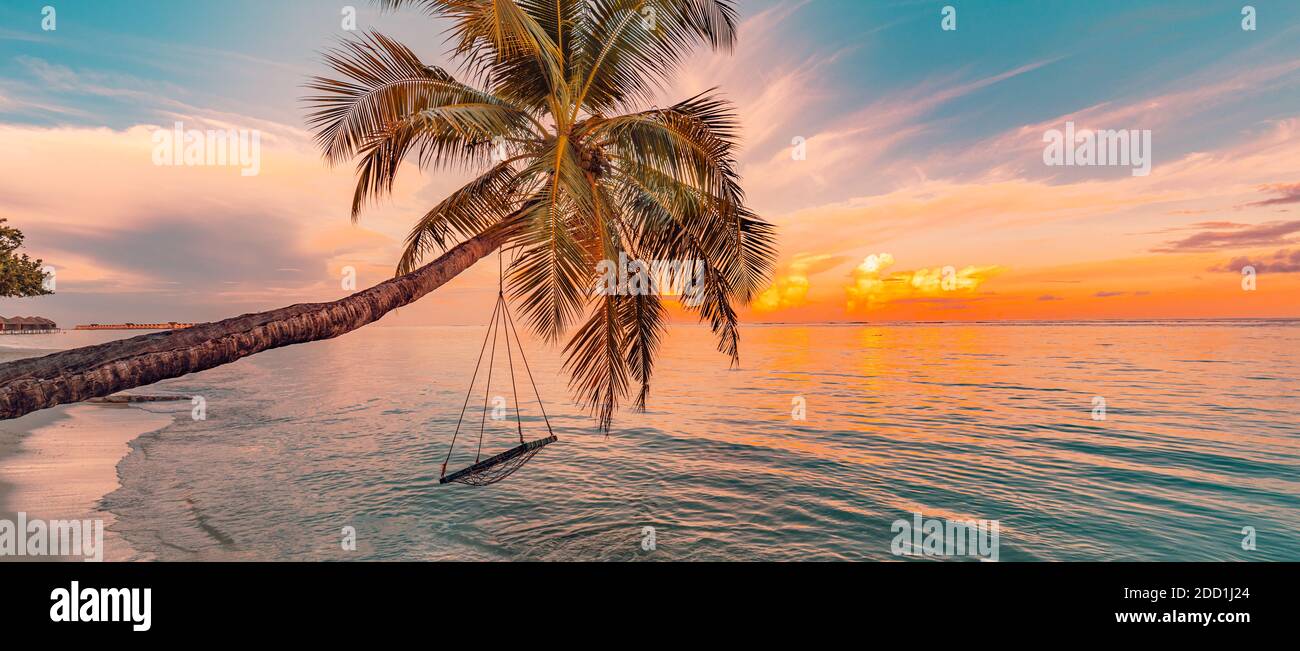 Tropical beach sunset as summer landscape with luxury resort beach swing, calm sea for sunset beach landscape. Tranquil beach scenery summer vacation Stock Photo