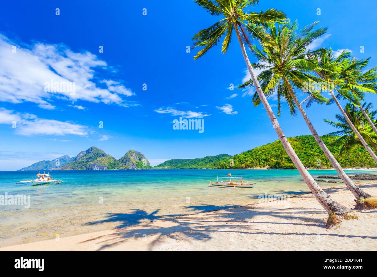 Beach with white sand, coconut palms and turquoise water in El Nido province, Palawan island in