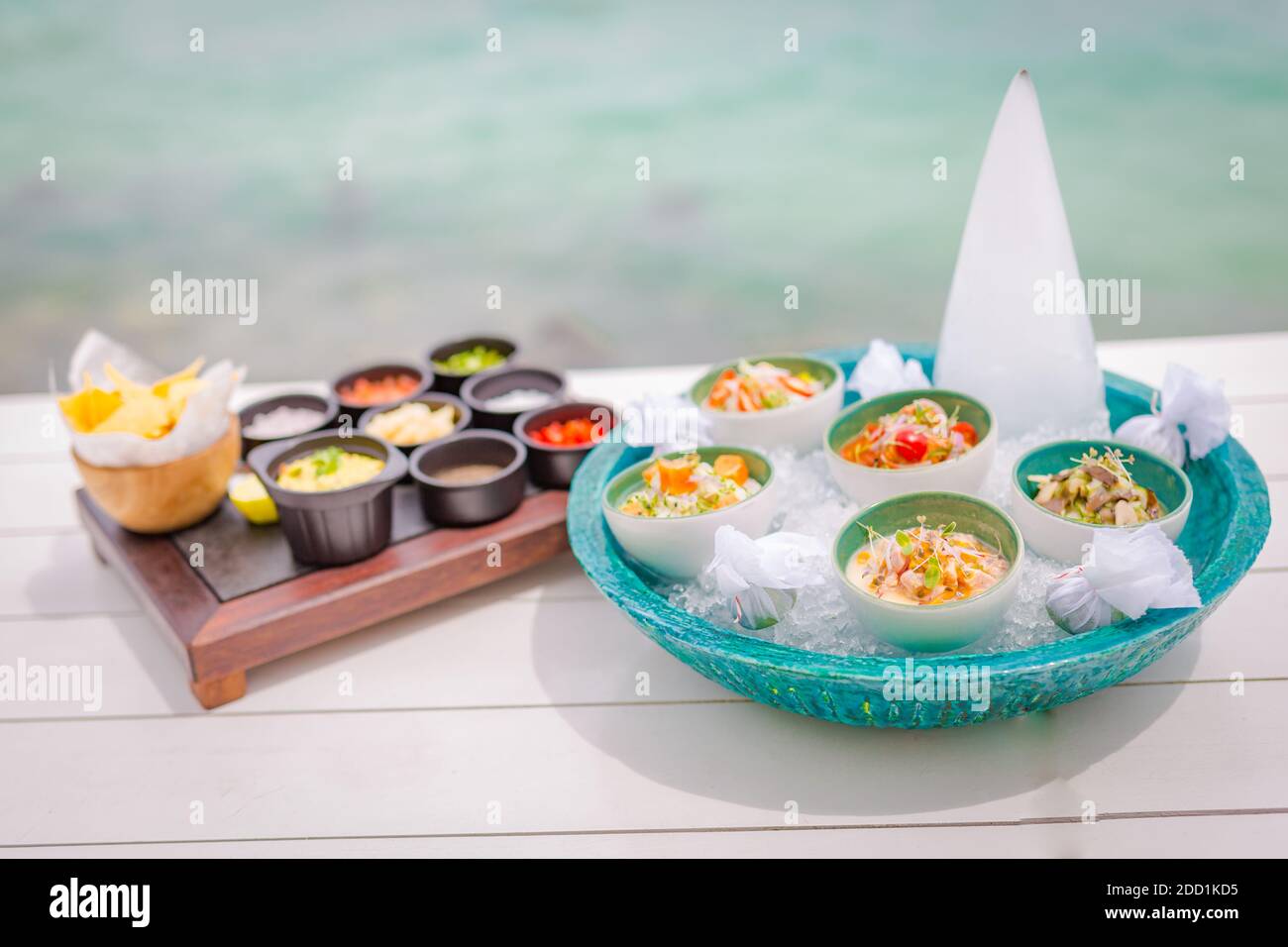 Ceviche gourmet sea food on white table. Delicious ceviche of shrimp with vegetables, spices and lime close up on a plate. Luxury outdoor restaurant Stock Photo