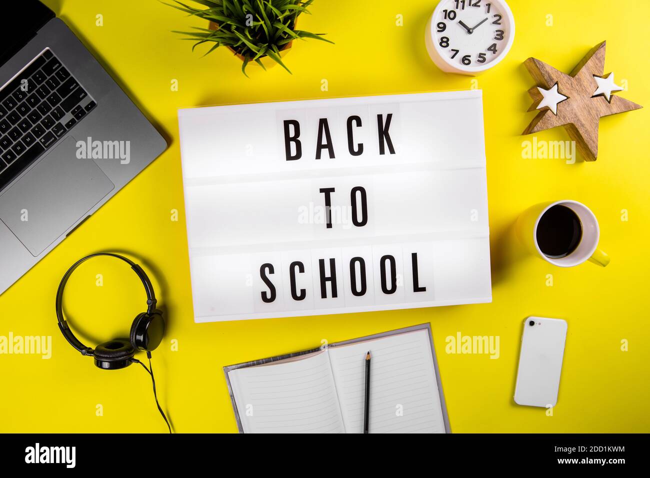 Back to school text on lightbox on modern yellow office work table Stock Photo