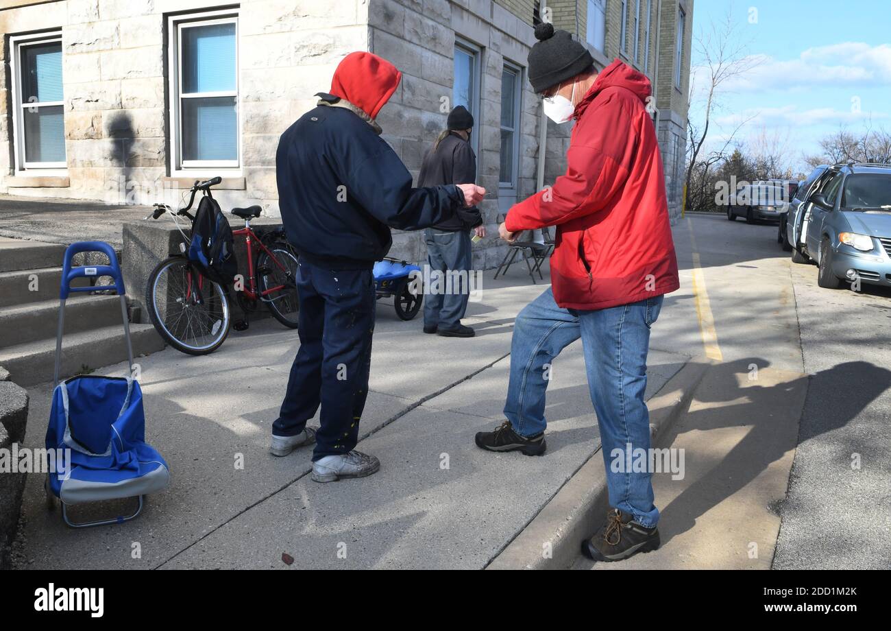 Racine, Wisconsin, USA. 23rd Nov, 2020. Volunteers at Holy Communion Lutheran Church in Racine, Wisconsin, bring food, including turkeys, to clients of their twice-weekly drive-in food pantry Monday November 23, 2020, three days before Thanksgiving. JOHN LEHMAN, right, checks in client ANTHONY KOLLER who came on foot with a hand cart. MICHAEL MULVEY, center, came by bicycle. The food pantry serves about 4900 families (16,700 individuals) annually. (Credit Image: © Mark HertzbergZUMA Wire) Credit: ZUMA Press, Inc./Alamy Live News Stock Photo