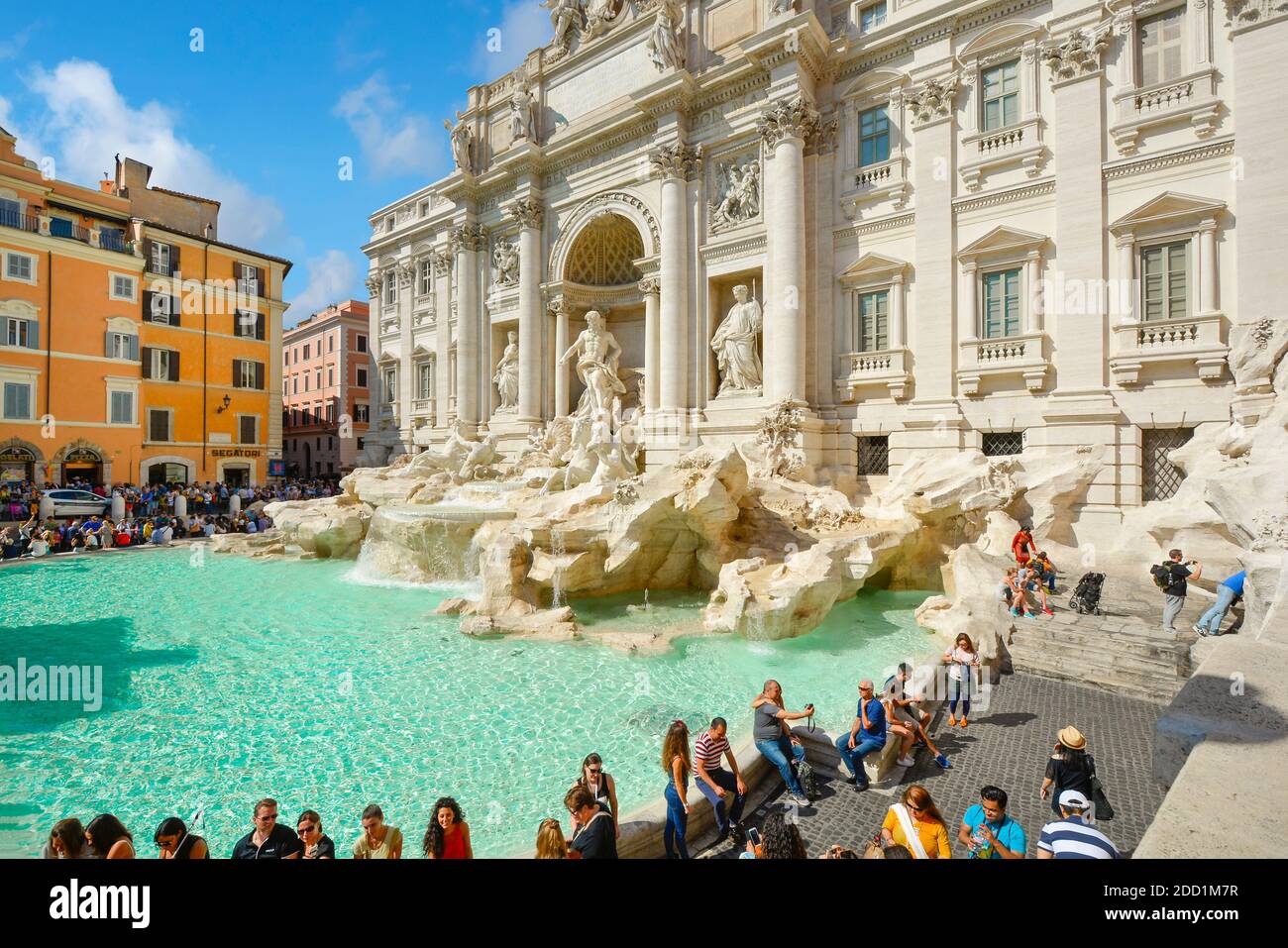 A large crowd of tourists visit the famous Bernini Trevi Fountain in