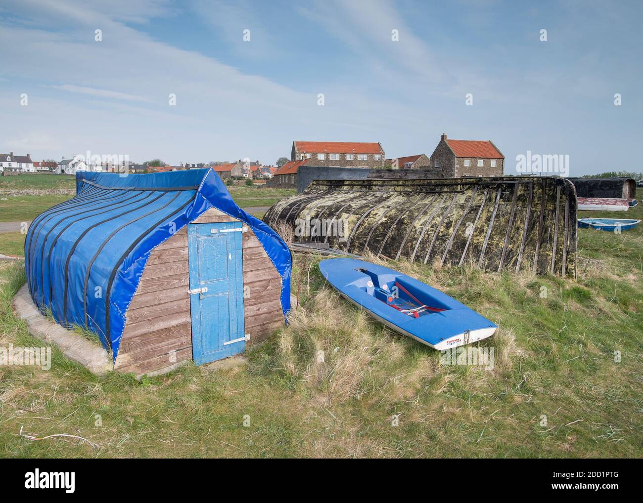 Upturned herring boats now used as fishing sheds on the Holy island of Lindisfarne, England. Stock Photo