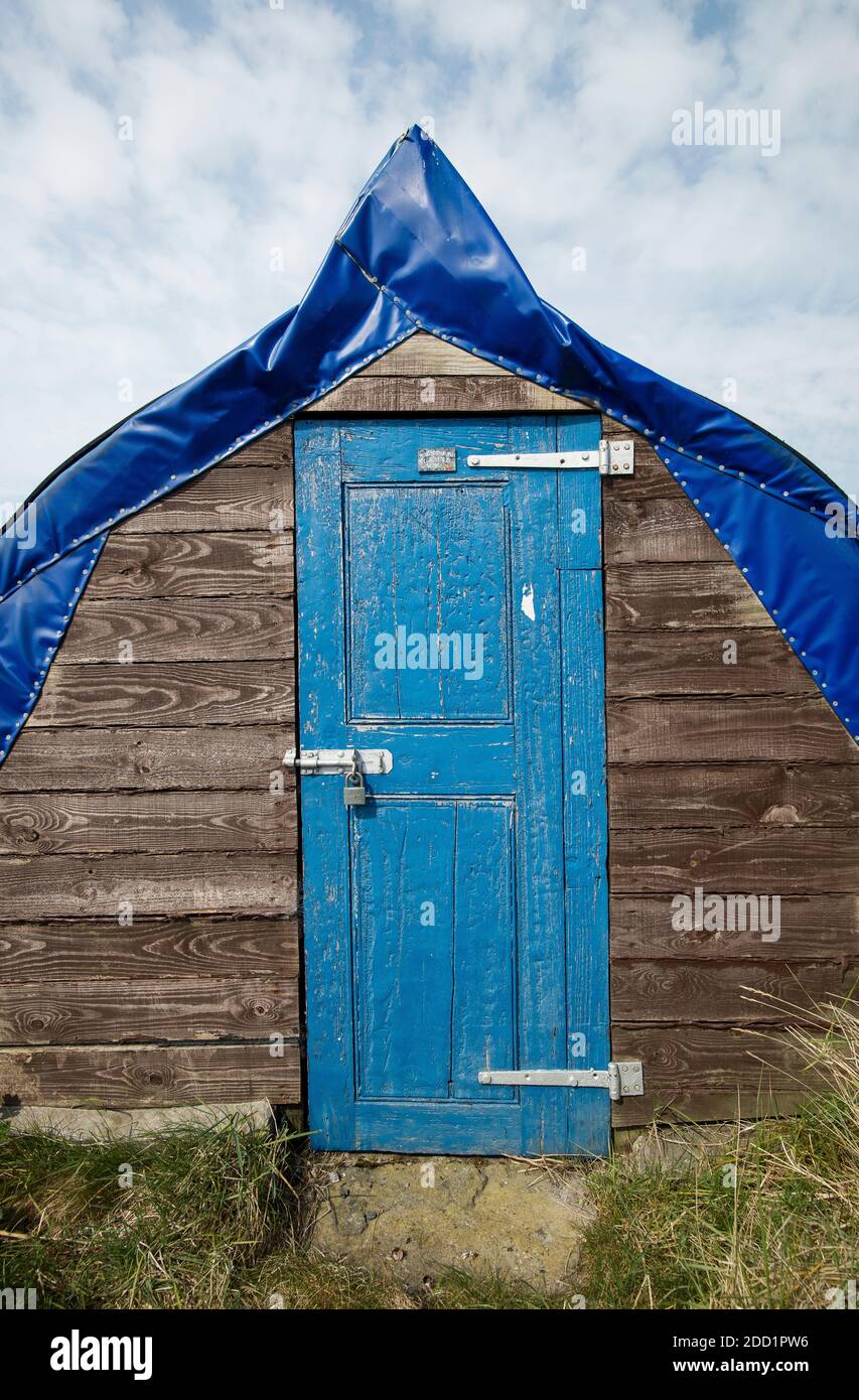 Upturned herring boats now used as fishing sheds on the Holy island of Lindisfarne, England. Stock Photo
