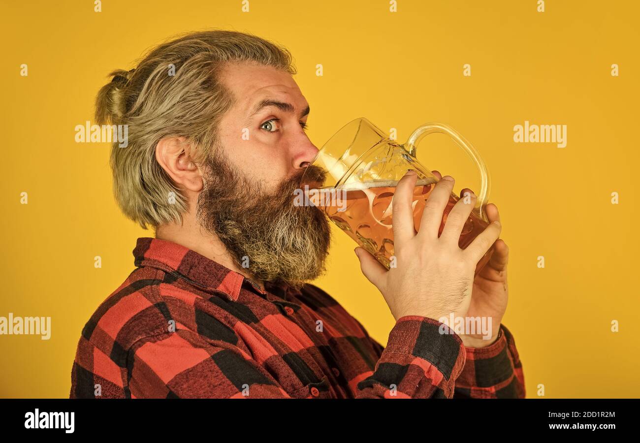 drink your beer. trying a new beer. brutal hipster drink beer. mature bearded man hold beer glass. mug of alcohol beverage. confident bartender. barman in bar. resting at pub. Cheers. sport bar. Stock Photo