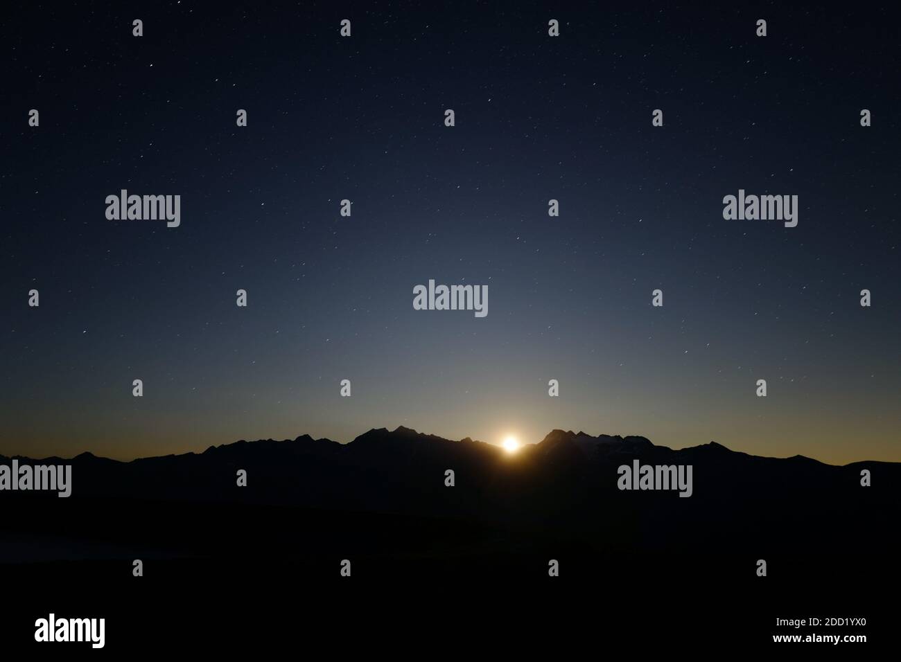 The silhouette of the mountains south of Bellwald against a full moon, in the Swiss Alps, while on a volbiv adventure. Stock Photo