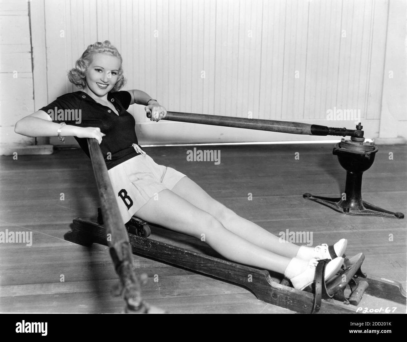BETTY GRABLE 1937 Leggy Publicity Portrait on Rowing Machine Paramount Pictures Stock Photo