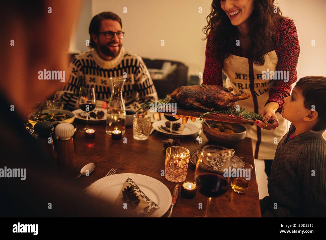 Woman serving roasted turkey to family. Female serving thanksgiving turkey for family dinner at