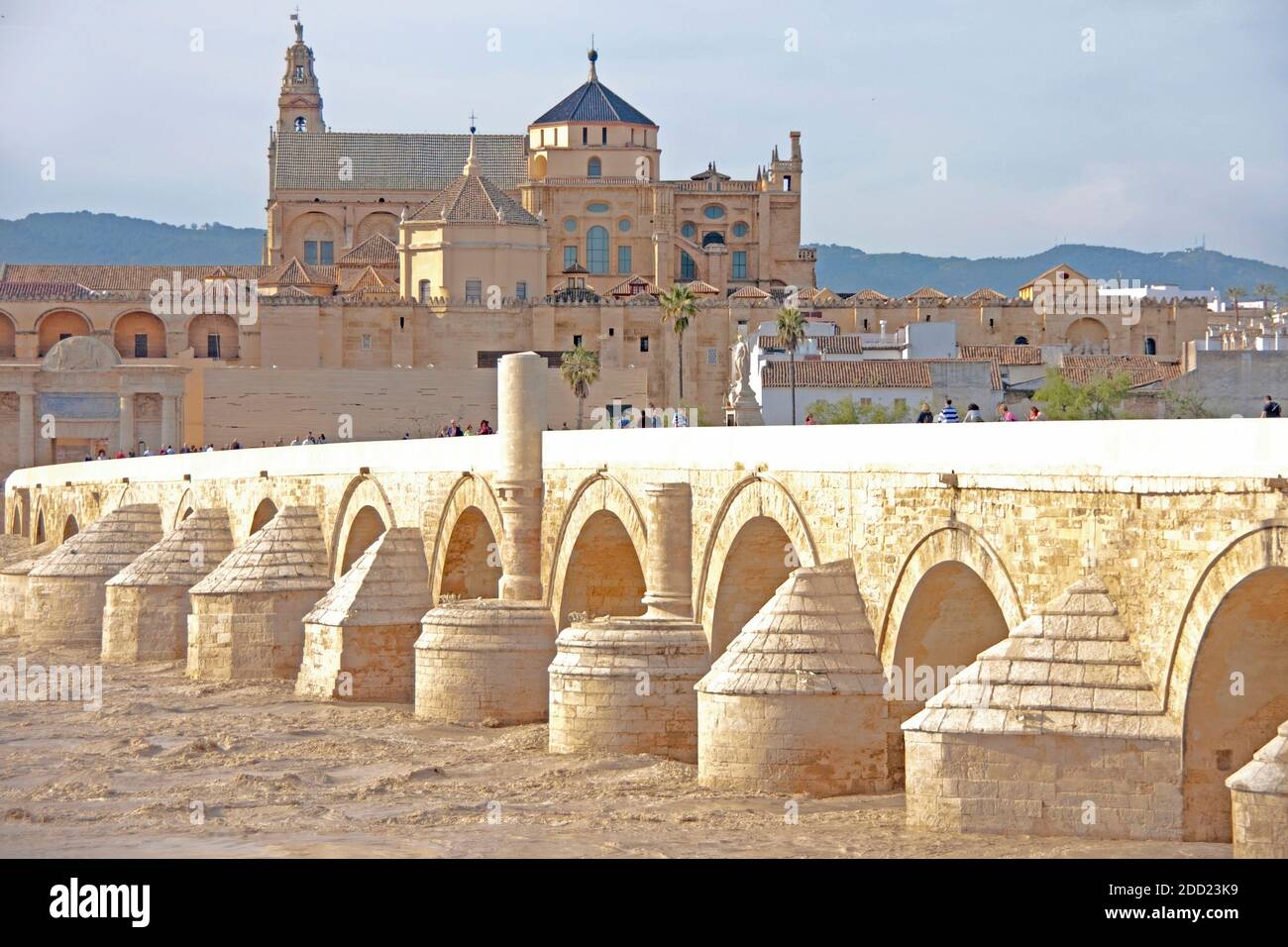 Roman bridge over muddy Guadalquivir River to Great Mosque and Cathedral in Cordoba, Spain. Stock Photo