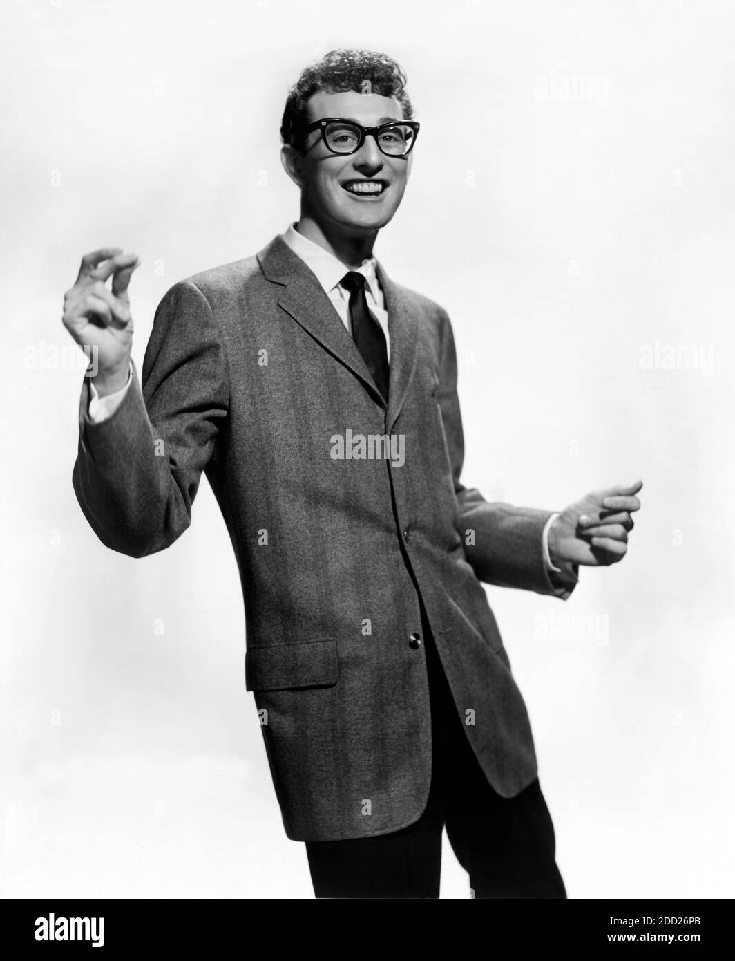 1958 ca. , USA : The celebrated  Rock'n Roll  star , guitarist , singer and songwriter BUDDY HOLLY ( 1936 - 1959 ). Buddy Holly dead on the ill-fated flight tyhe day 3 february 1959 that crashed on Clear Lake and killed him and also J.P. The Big Bopper Richardson and Richie Valens . Unknown photographer for Brunswick Records .-  ROCKABILLY - POP MUSIC - ROCK AND ROLL - ROCK'N ROLL - MUSICA LEGGERA - portrait - ritratto  - musicista - musician - chitarrista - musicista - ROCK - portrait - ritratto - ANNI CINQUANTA - 50's - '50 - lens - smile - sorriso - disastro aereo - dance - danza ---  ARCHI Stock Photo