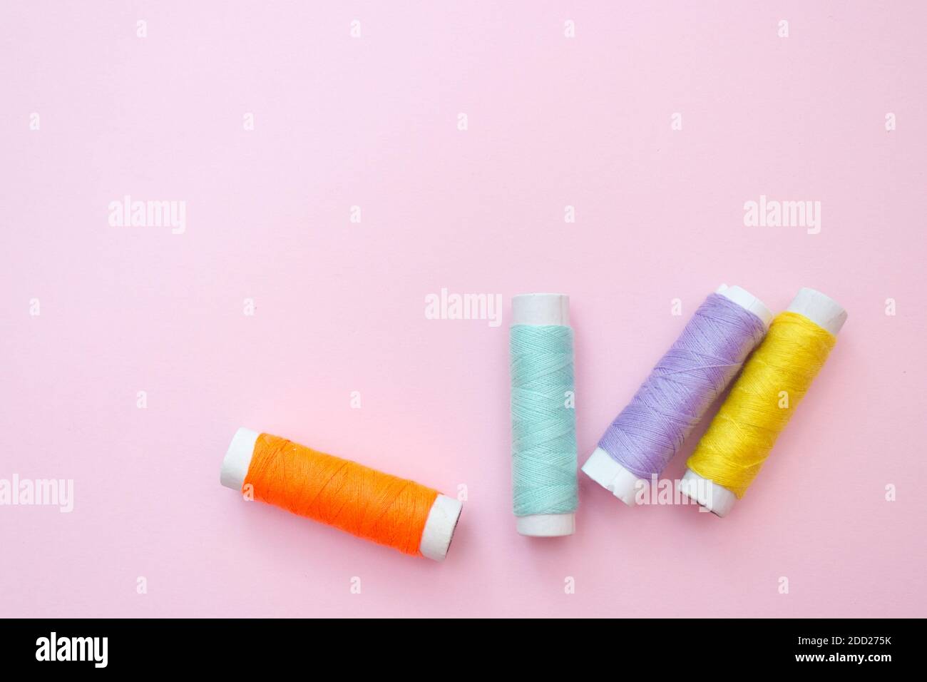 Premium Photo  Color sewing threads on pink background