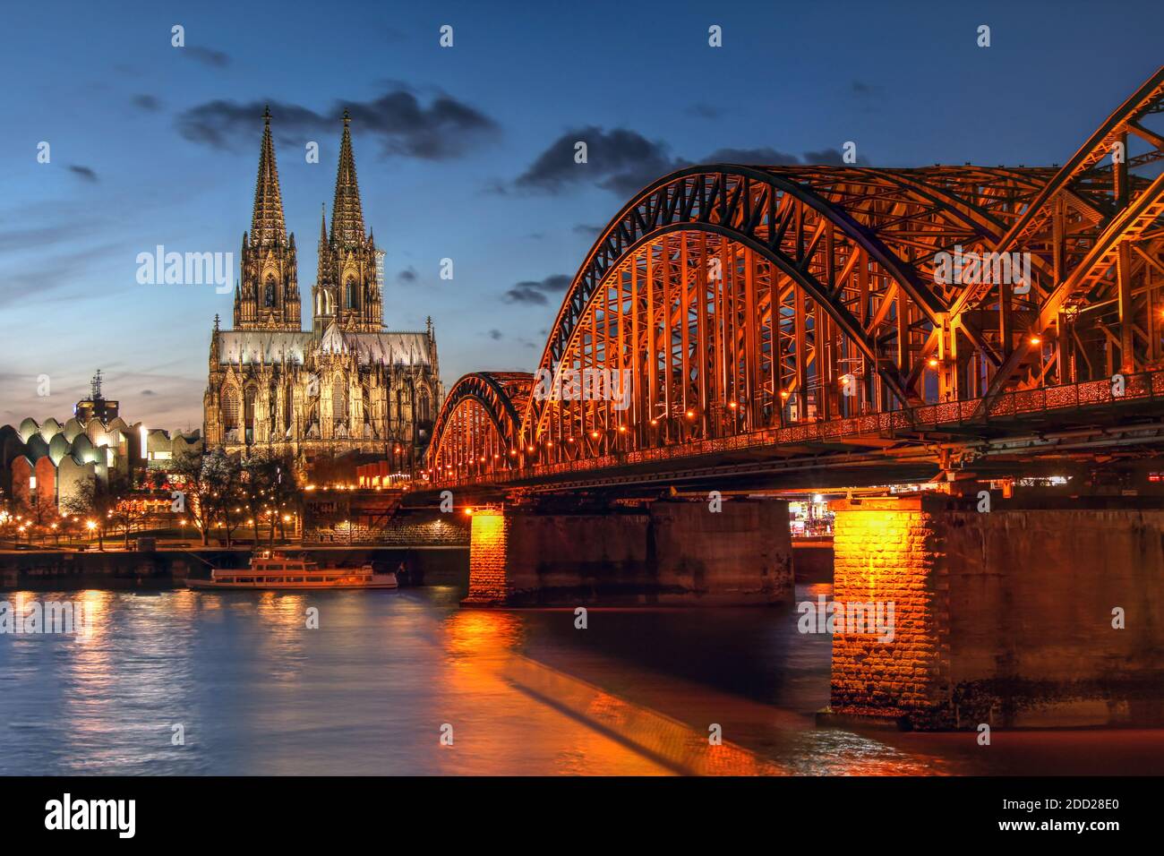 Sunset scene in Cologne (Koln) in North Rhine Westphalia region of Germany, surprising the Cologne Cathedral (Kolner Dom) and the Hohenzaller Bridge o Stock Photo