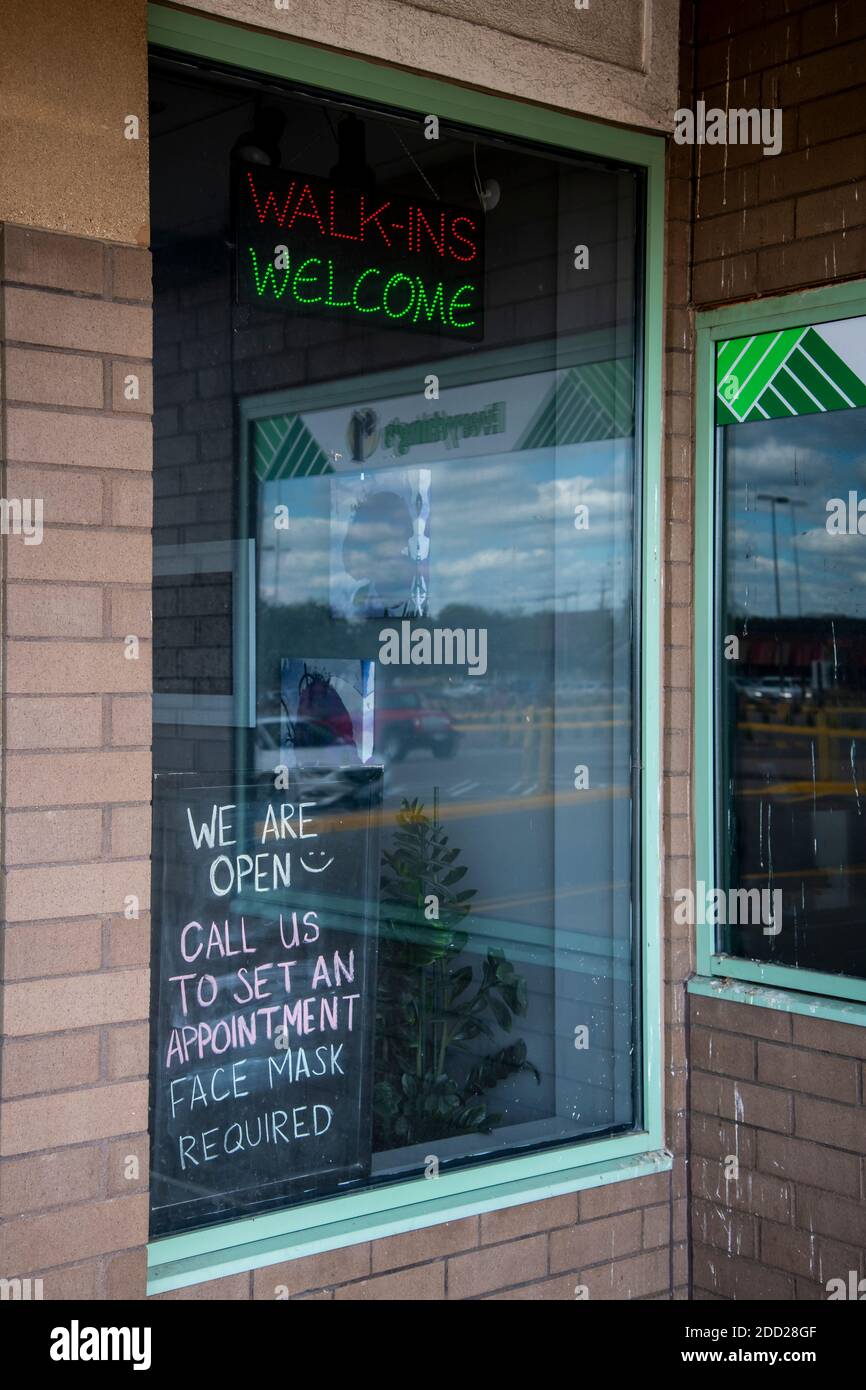 Roseville, Minnesota. After opening during the coronavirus pandemic a nail salon lights up walk-ins welcome sign. Stock Photo