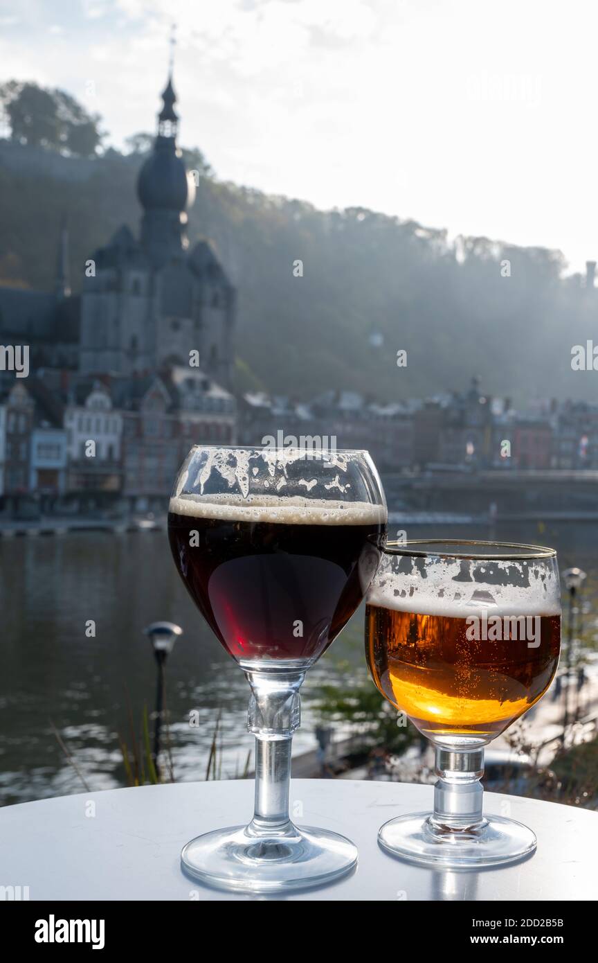 Drinking of dark and strong Belgian abbey beer with cheeses in sunny day with nice view on Maas