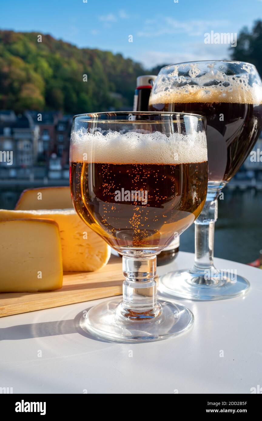 Drinking of dark and strong Belgian abbey beer with cheeses in sunny