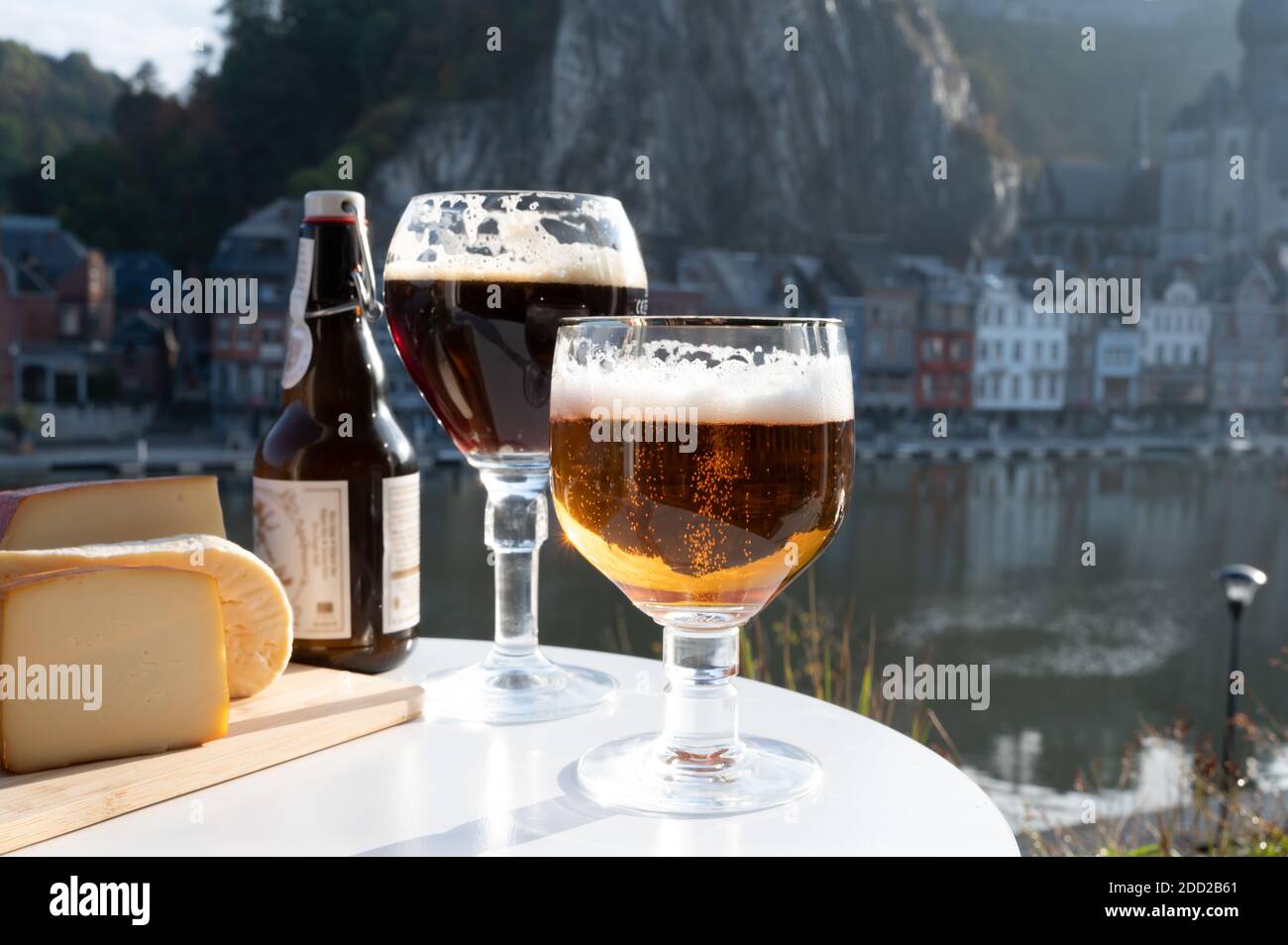 Drinking of dark and strong Belgian abbey beer with cheeses in sunny day with nice view on Maas