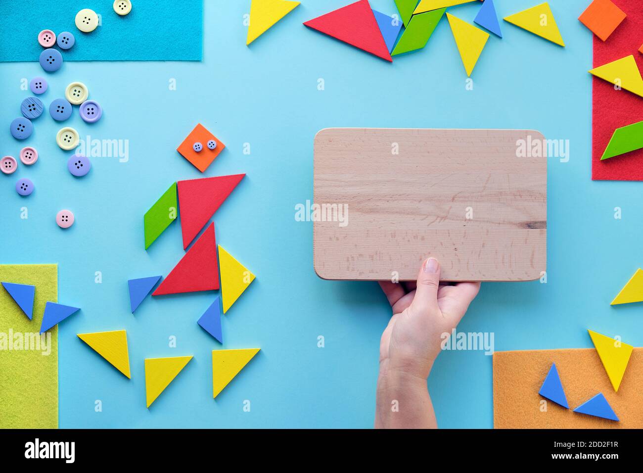 Creative design for Autism World day with tangram puzzle triangles, pictogram and hand with board Stock Photo