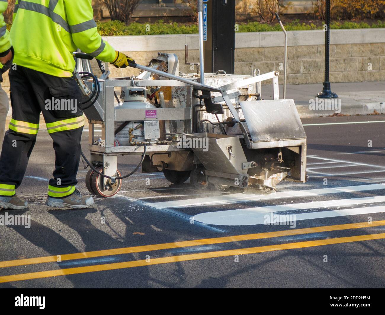 Pavement painting crew using painting machine laying down traffic