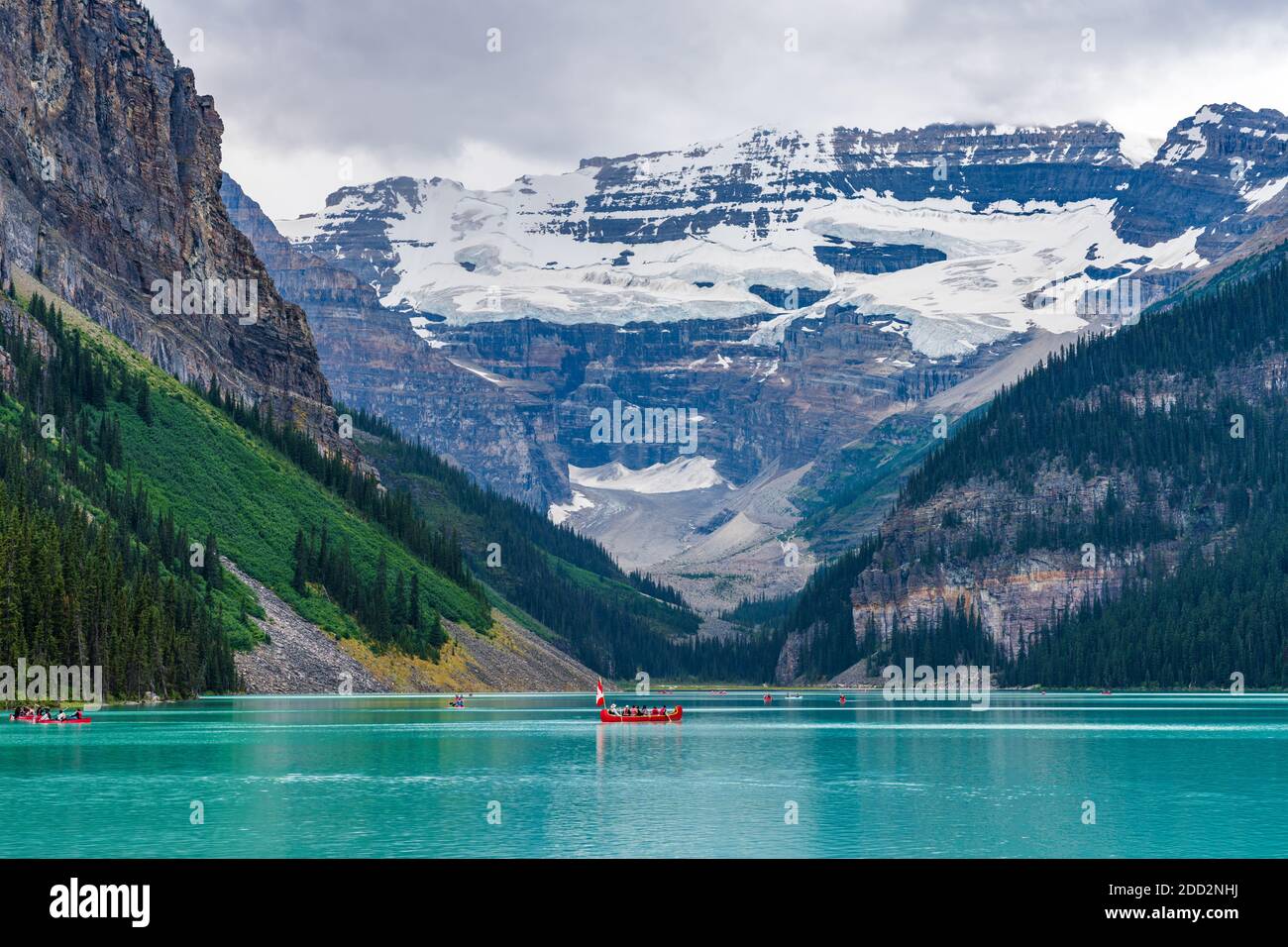 Canoeing on Lake Louise in summer day. Tourists enjoy leisure water activities on the turquoise color lake in Banff National Park, Alberta, Canada. Stock Photo