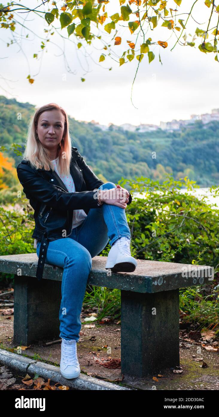 girl sitting on a bench in the autumn park near the lake Stock Photo ...