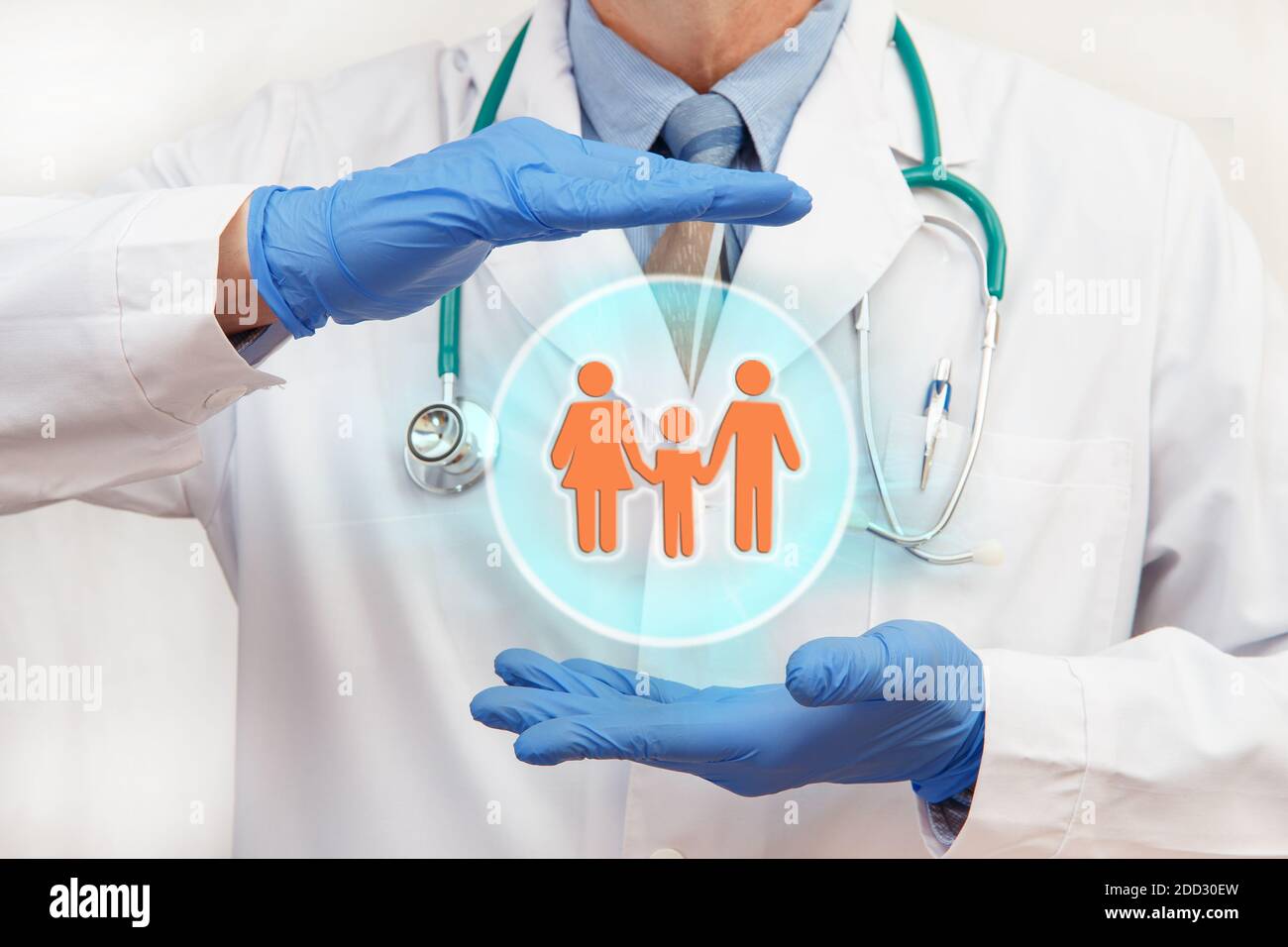 The doctor holds a protective sphere with the image of a family. Family insurance. Family doctor. Stock Photo