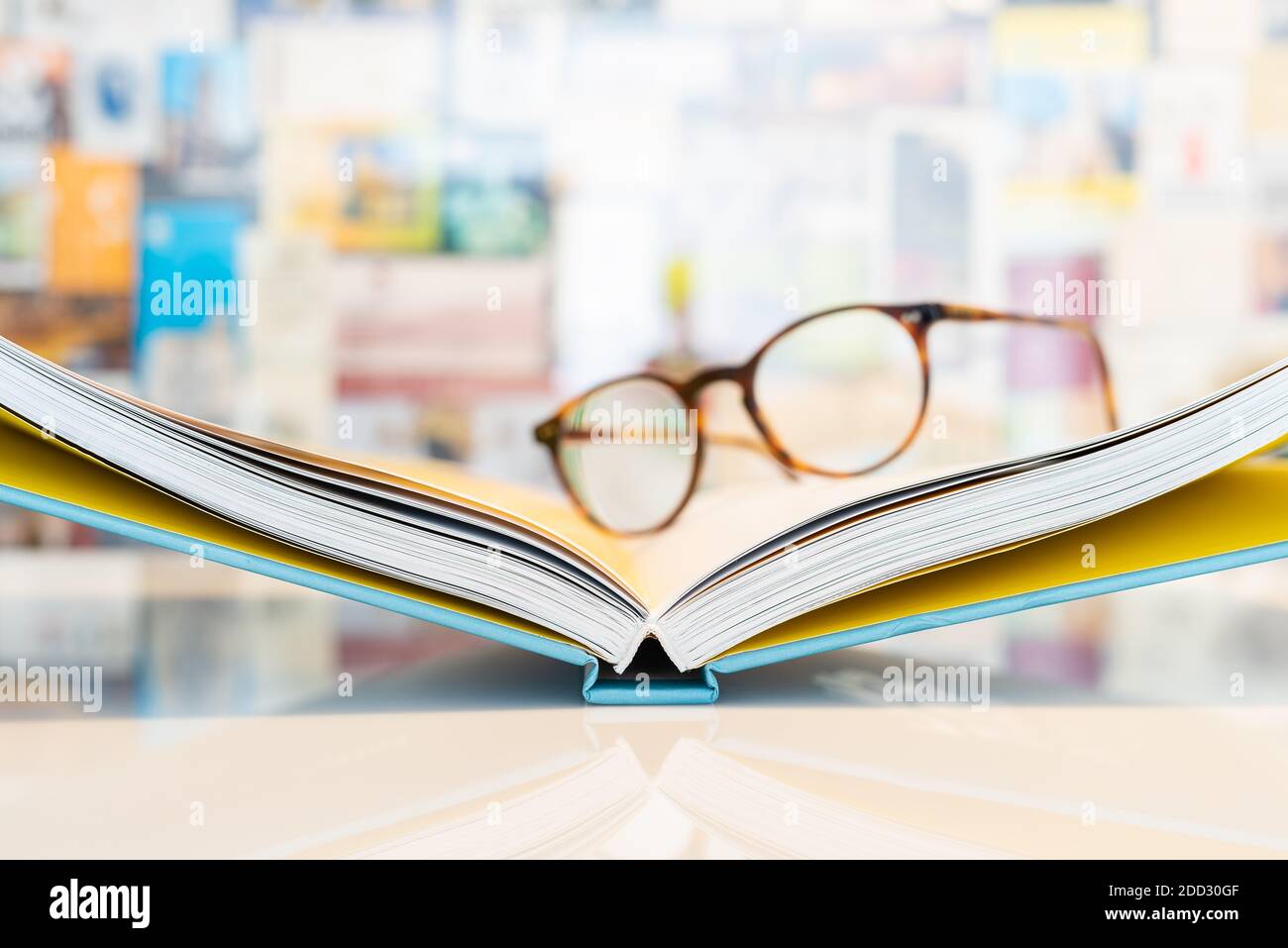 Open book with soft blurred reading glasses in background Stock Photo