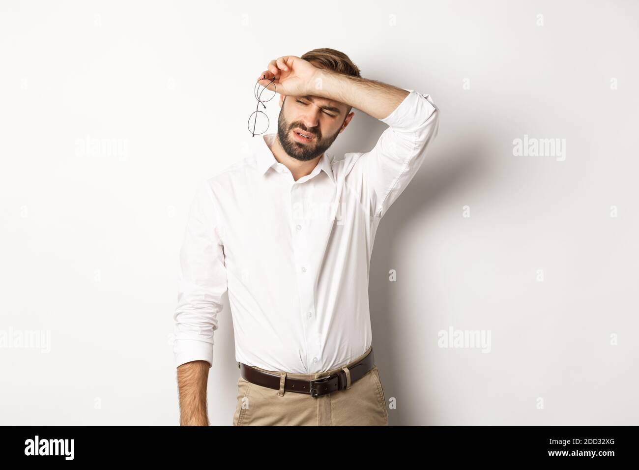 Tired office worker takeoff glasses, wiping sweat off forehead with