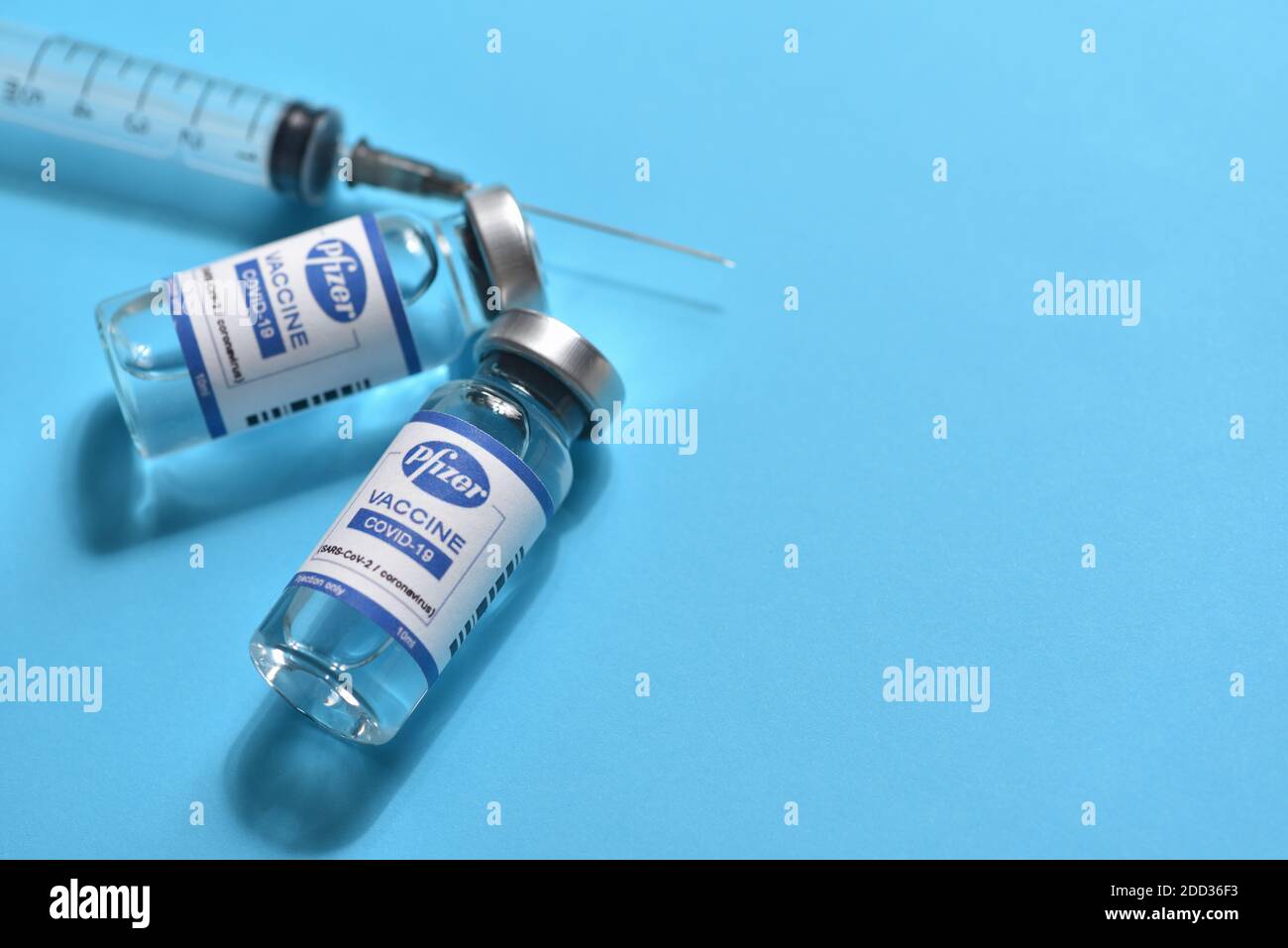 STARIY OSKOL, RUSSIA - NOVEMBER 23, 2020: Pfizer coronavirus vaccine concept and syringe on blue background with copy space Stock Photo