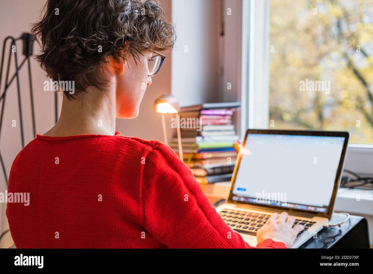 Young caucasian entrepreneur woman with earphones working online from home on computer laptop, online meeting Stock Photo