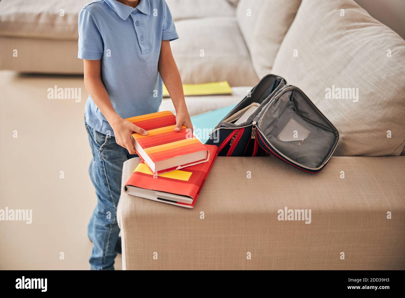 Unrecognisable boy taking books out of a school-bag Stock Photo