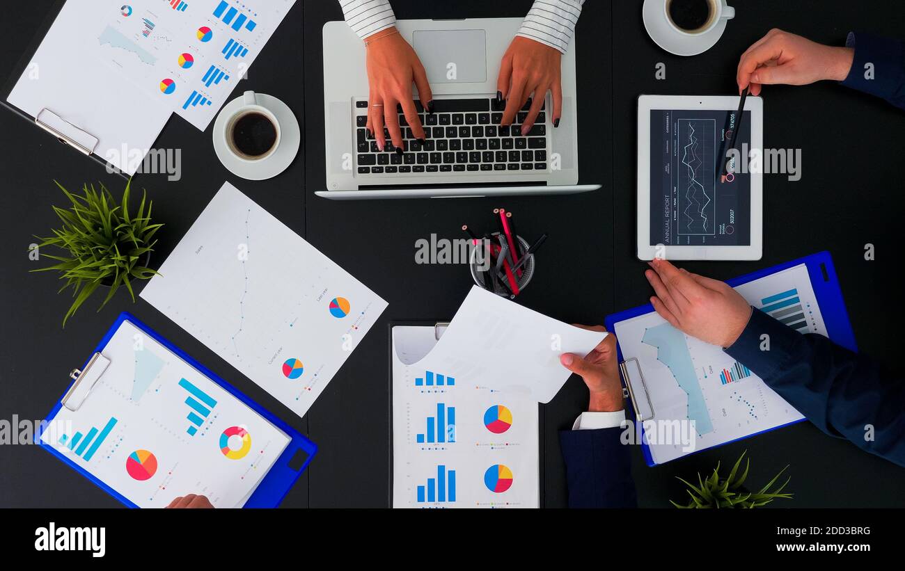 High angle view of business team working with financial reports at ...