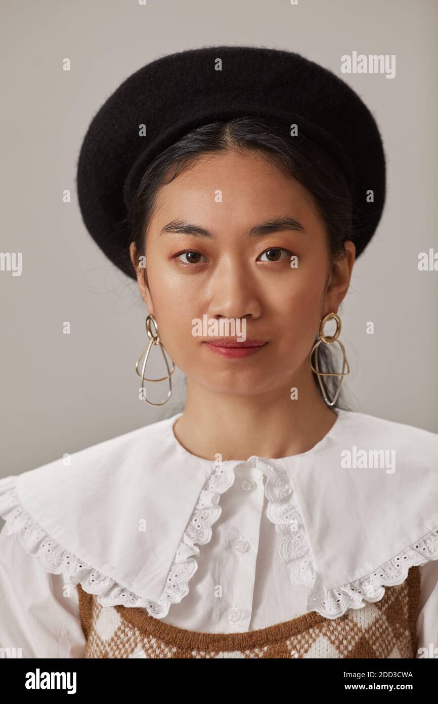 Portrait of Asian young woman in elegant hat looking at camera Stock Photo