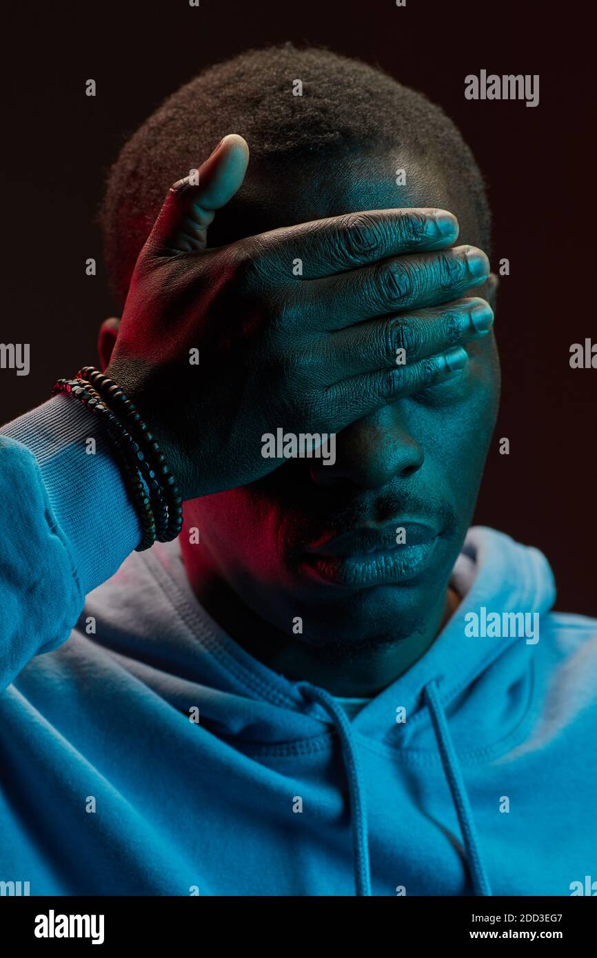 Close-up of African man covering his face with hand Stock Photo
